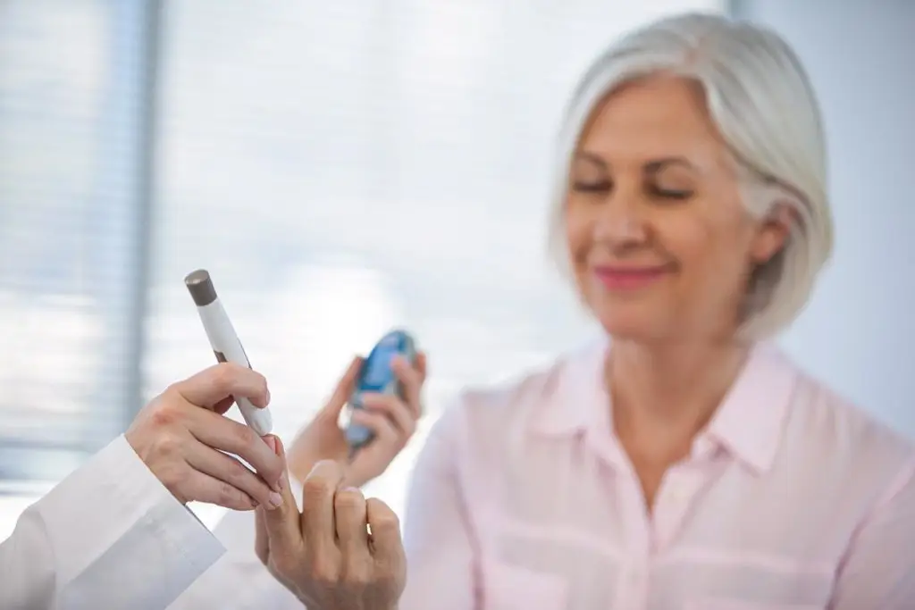 Health care provider checking glucose level in diabetic patient in clinic