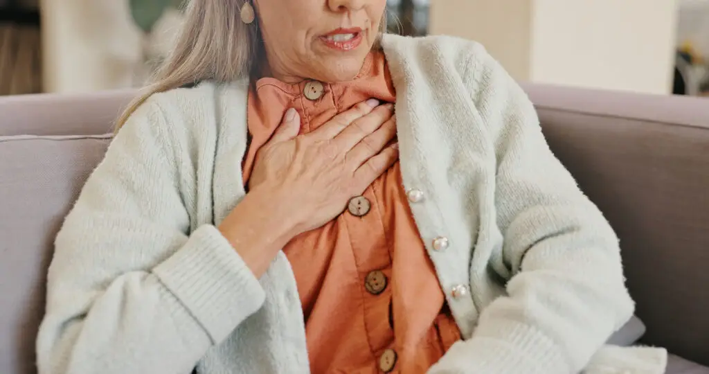 Pain in the heart hnd gesture of senior woman with an expression of panic