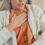 Pain in the heart hnd gesture of senior woman with an expression of panic